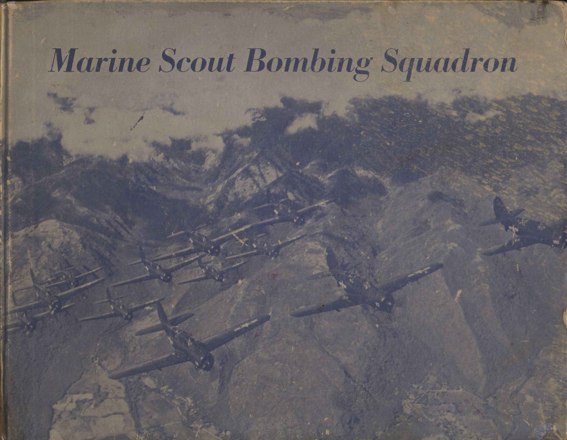 A blue and gray hardback book show in landscape orientation. Cover photo is of vintage SBD-Dauntless planes flying in formation over the mountains of Hawaii during World War II. 